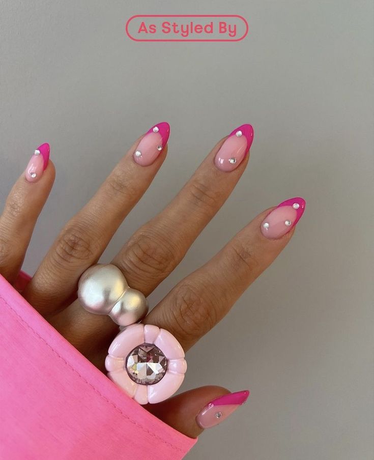 Playful Vibrant Nail Design with Soft and Bold Pink Tips, Accented by Shimmering Rhinestones and Oversized Rings.