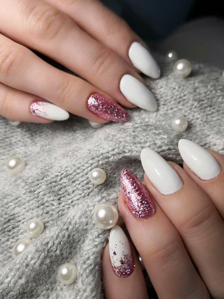 Sophisticated Oval and Almond Nail Design with White Polish and Shimmering Pink Glitter Accents.