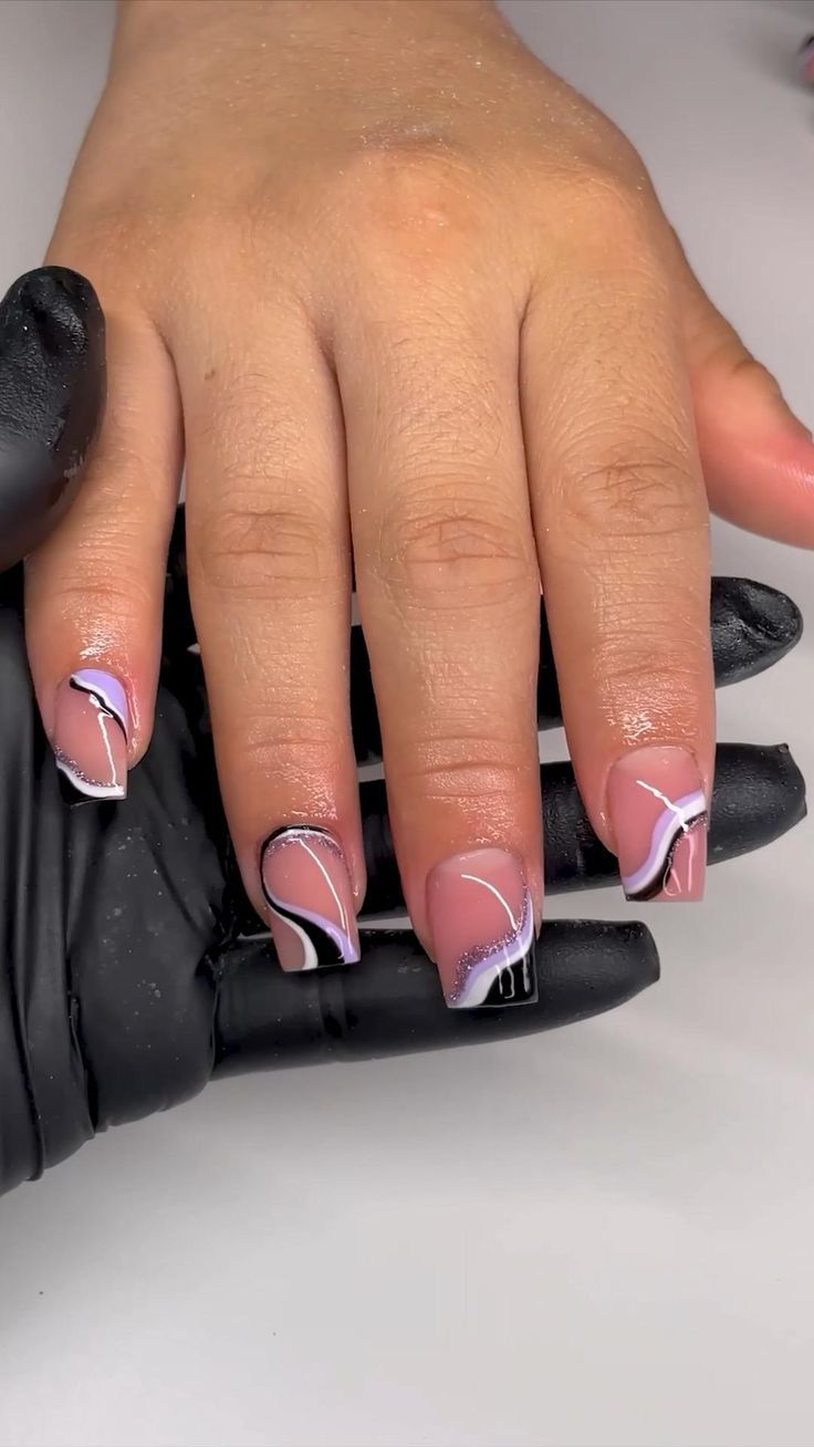 Chic Elegant Nail Design: Soft Pink Base with Intricate Black and White Swirls.