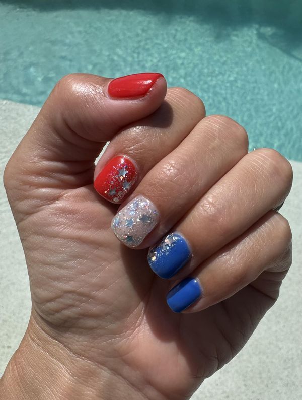 Vibrant Colorful Nail Design: Eye-Catching Red, Blue, and Glittery Accents Perfect for Summer Celebrations.