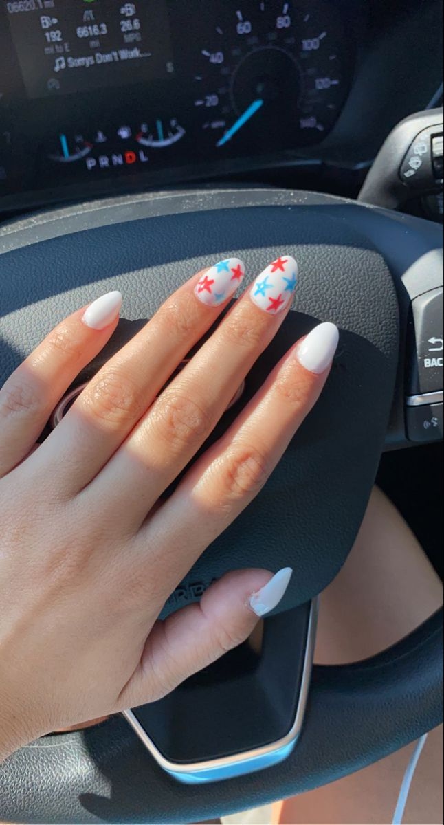 Vibrant Summer Nail Design with Whimsical Star Patterns in Red and Blue on a Clean White Base.