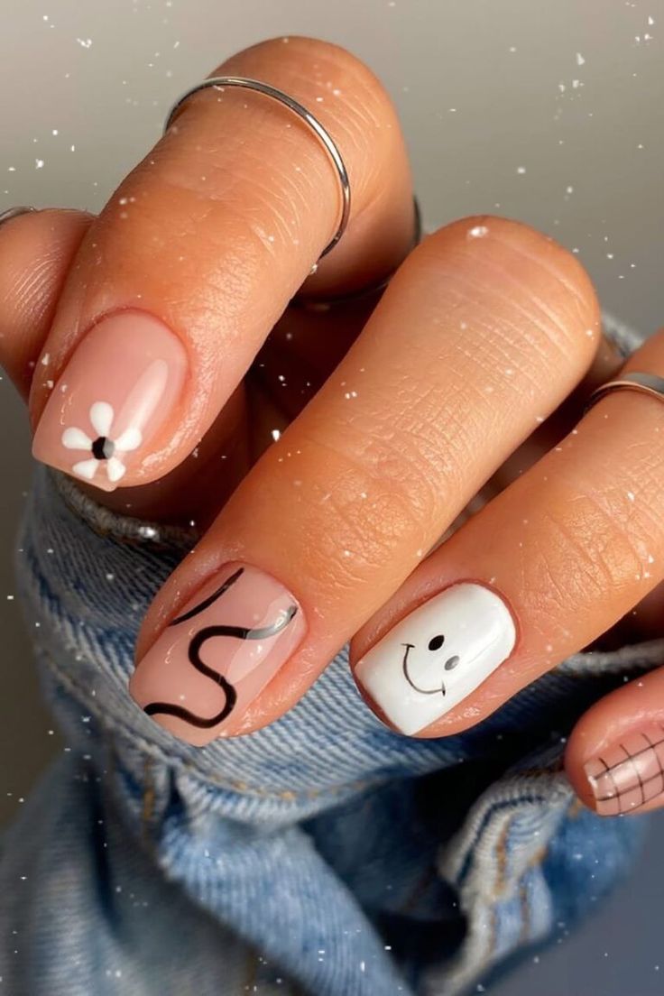 Whimsical Nail Art: Soft Nude Base with Floral and Smiley Face Accents