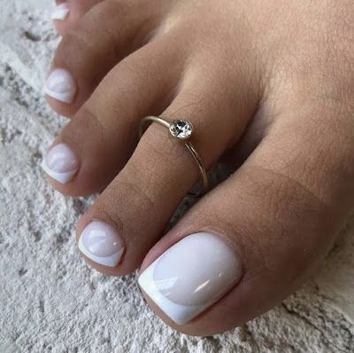 Elegant White Polish Pedicure with French Tip and Sparkling Rhinestone Accent.