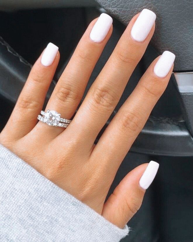 Chic Elegant White Nail Design Enhanced by a Sparkling Engagement Ring.