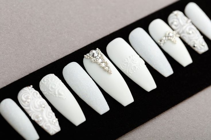 Chic Elegant White Nail Design with Matte and Glossy Finishes, Intricate Patterns, and Gem Embellishments.