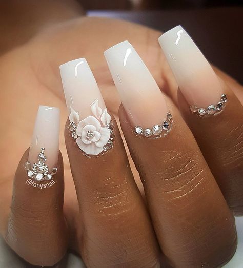 Sophisticated Ombre Nails: Soft Pink to Crisp White with Floral Embellishments and Rhinestones.