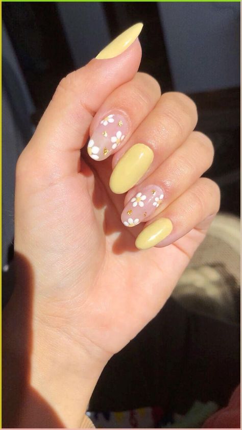 Whimsical Spring Nail Art: Elegant Yellow with Delicate White Flowers on Pastel Pink Background.