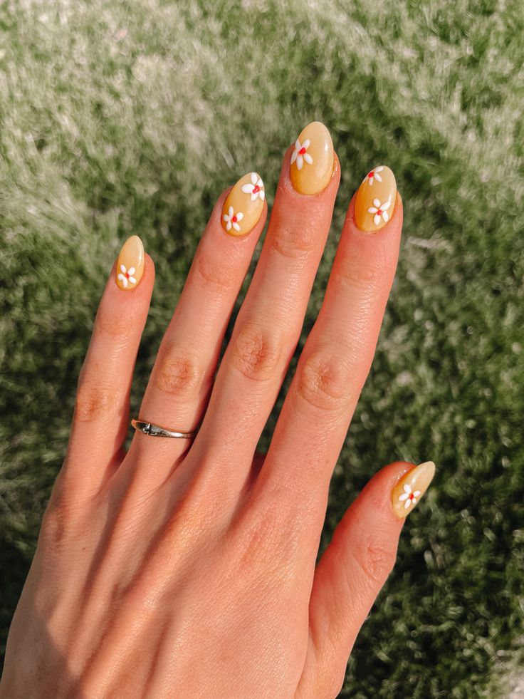 Cheerful Bright Yellow Nail Design with Delicate White Flowers for an Elegant Spring Look.