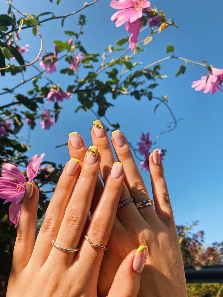 Playful Summer Nail Design: Soft Pink and Vibrant Yellow with Ombre and Glitter Accents.