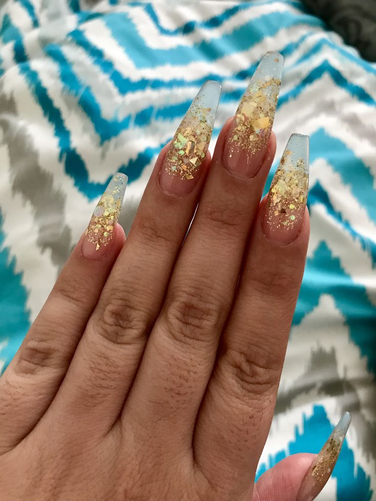 Glamorous Gradient Nail Art: Soft Pink with Translucent Tips and Gold Foil Flakes.