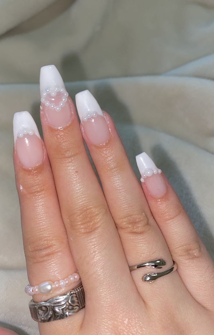 Sophisticated French Tip Nail Design with Pearl Accents for Any Occasion.