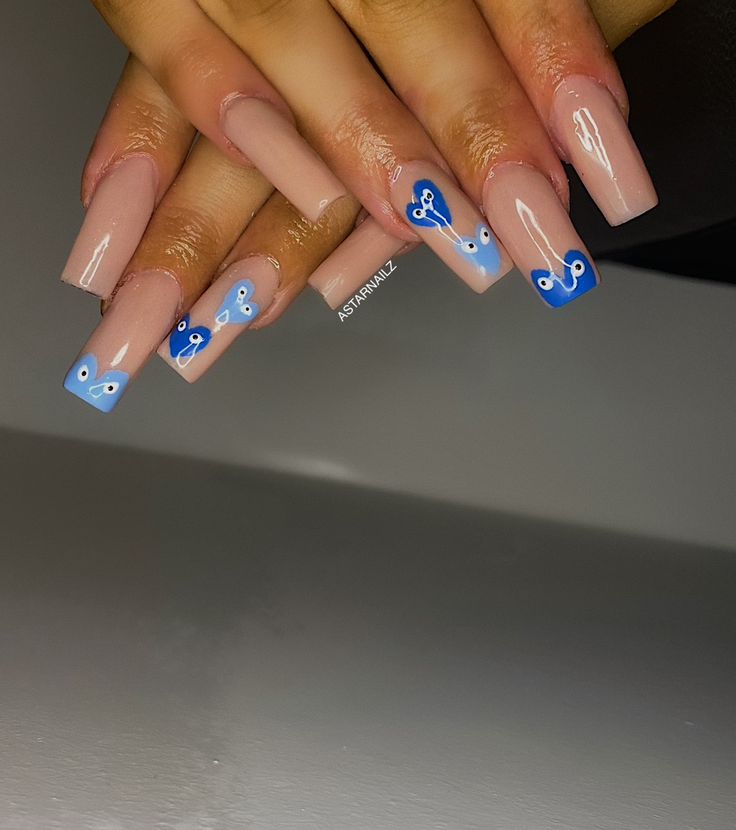 Elegant Nude and Blue Nail Design with Vibrant Accents and Playful Swirls.