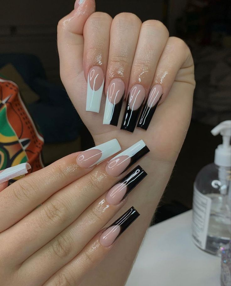 Chic Nail Design: Bold Contrast of Nude and Black with Elegant White Accents.