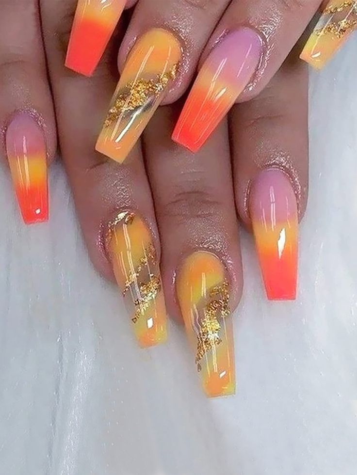 Vibrant Ombre Nails: A Summer-Inspired Blend of Orange and Pink with Glitter Accents.