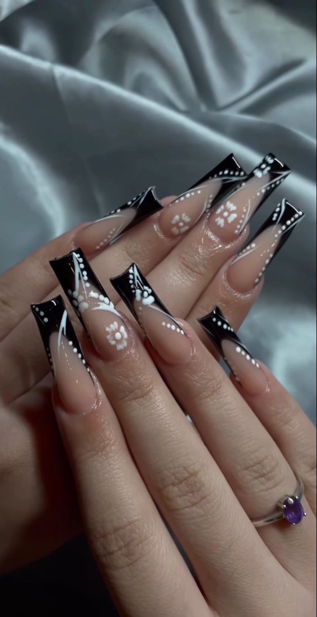 Sophisticated Black and White Floral Nail Design with Long Sharp Tips.