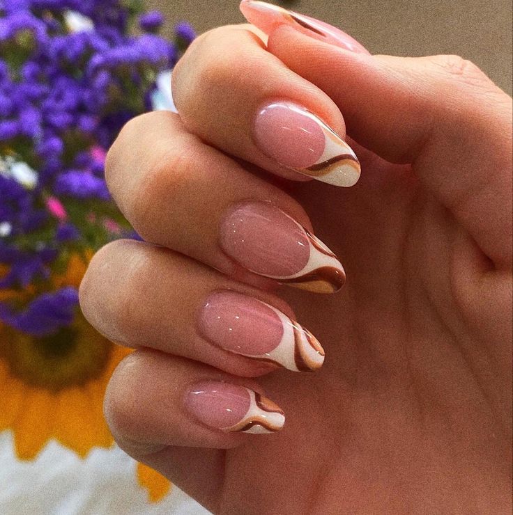 Sophisticated Soft Pink and Creamy White Nail Design with Elegant Marble Patterns and Earthy Toned Tips.