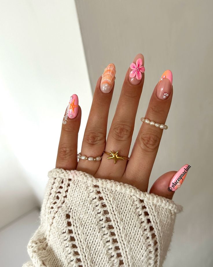 Playful Pastel Pink Nail Design with Vibrant Floral Accents for a Stylish Spring/Summer Look.