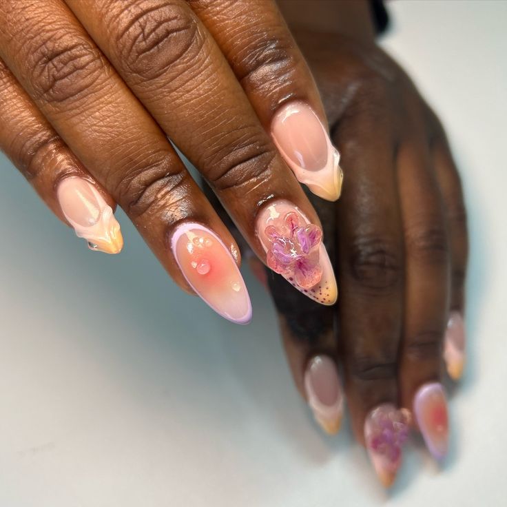 Chic Almond-Shaped Ombre Nails with Floral Accents and Glitter for Spring/Summer.