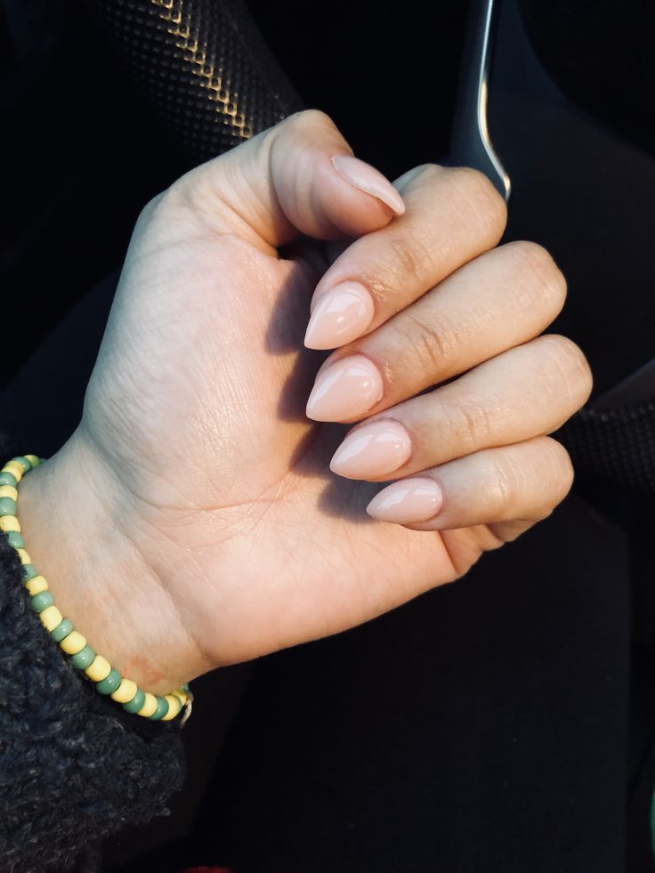 Chic Almond-Shaped Nails in Soft Nude Polish Enhanced by Colorful Bracelet