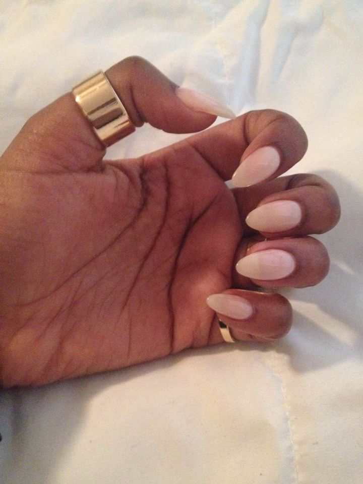 Sophisticated Almond-Shaped Nails with Soft Pink Polish and Chic Gold Rings for Modern Glamour.