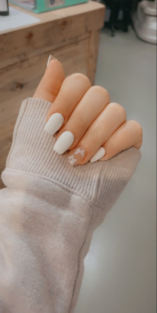 Chic and Modern Elegant Nail Design with Classic White Polish and Playful Heart Accent.