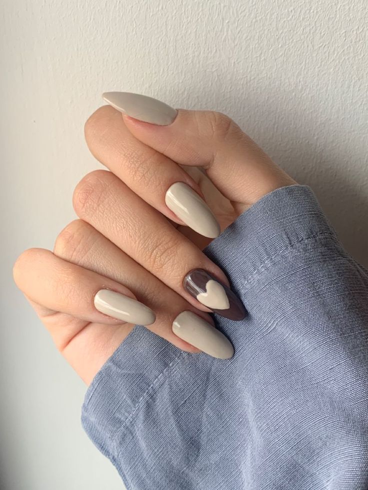 Elegant Neutral Nail Design with Almond Shape and Playful Accent.