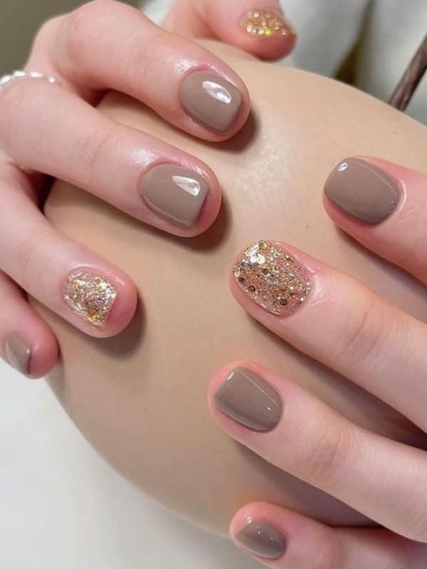 Chic Taupe Nail Design with Glamorous Golden Glitter Accents