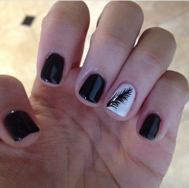 Chic Glossy Black and White Nail Design with Tropical Palm Leaf Accent.