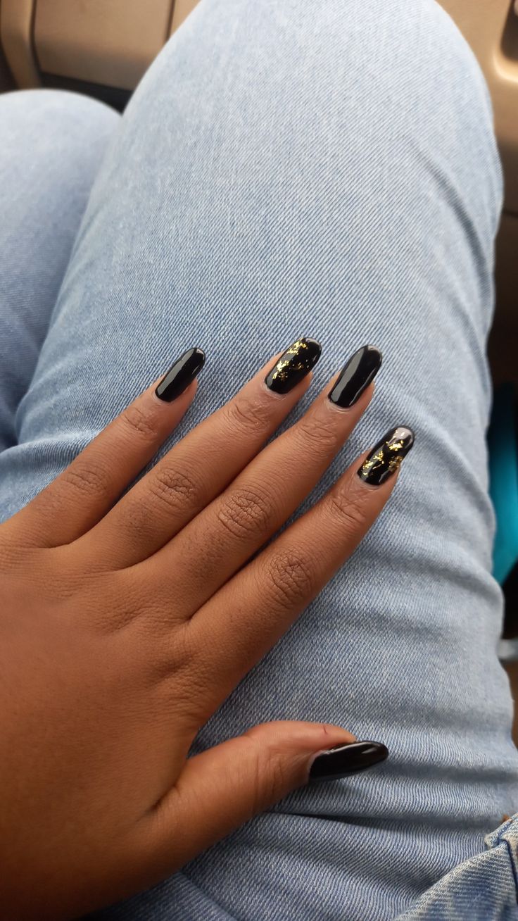 Chic Nail Design: Sleek Black Base with Glamorous Metallic Gold Accents