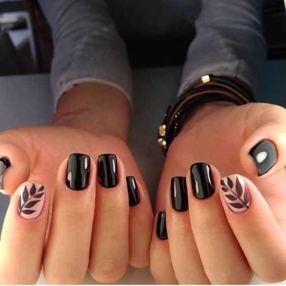 Chic Black Nail Design: Matte and Glossy Contrast with Nature-Inspired Leaf Accents.