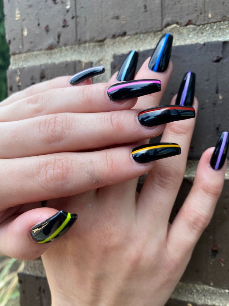 Bold Black Nail Design with Elongated Tips and Vibrant Color Accents.