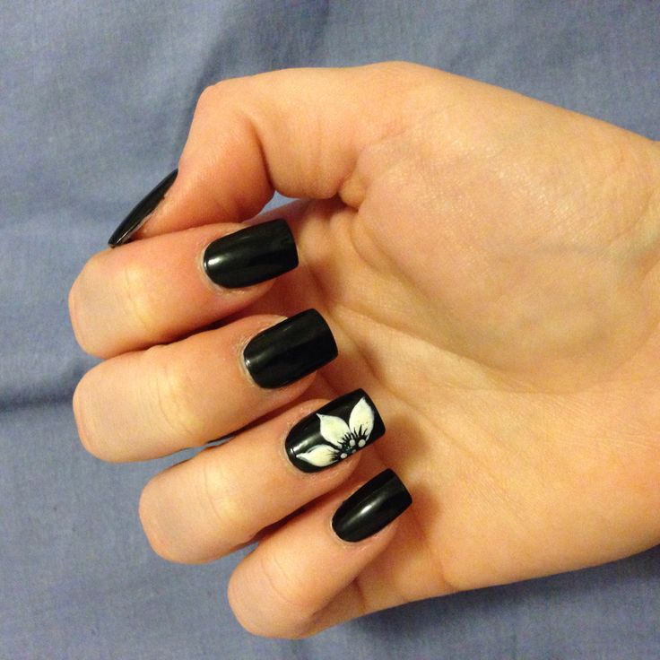 Modern Elegance: Striking Black Nails with Delicate White Floral Accent.