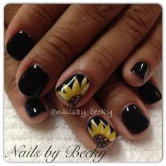 Chic Nail Design: Bold Black Polish with Vibrant Sunflower Accent.