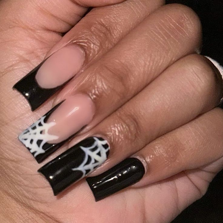 Edgy Black and Neutral Nail Design with Playful White Spiderweb Patterns.