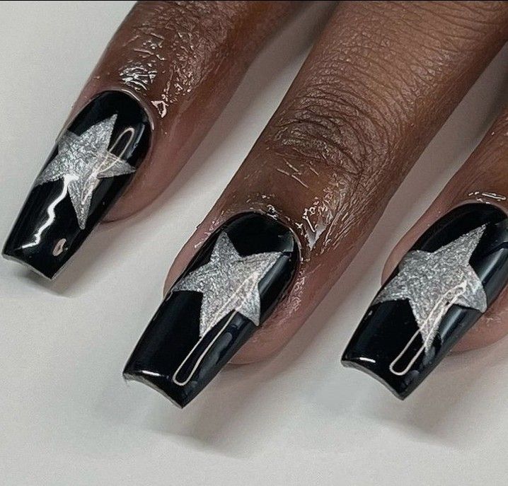 Bold Black Nail Design with Shimmering Silver Stars for a Unique, Playful Look.