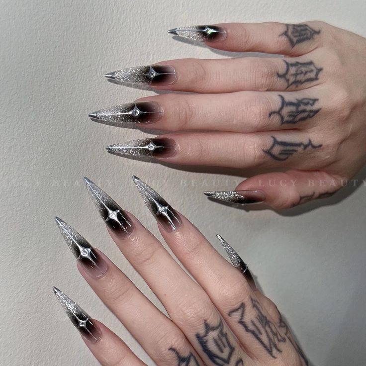 Bold Stiletto Nails with Glitter Gradient and Tattoo Art Make a Dramatic Fashion Statement