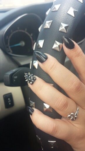 Chic Bold Black Nail Design with Pointed Tips and Edgy Metallic Accents