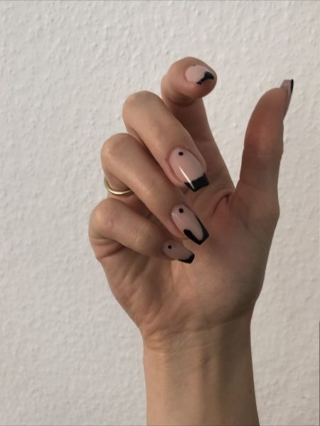 Chic Minimalist Nail Design: Nude Base with Stylish Black Tips and Artistic Accents