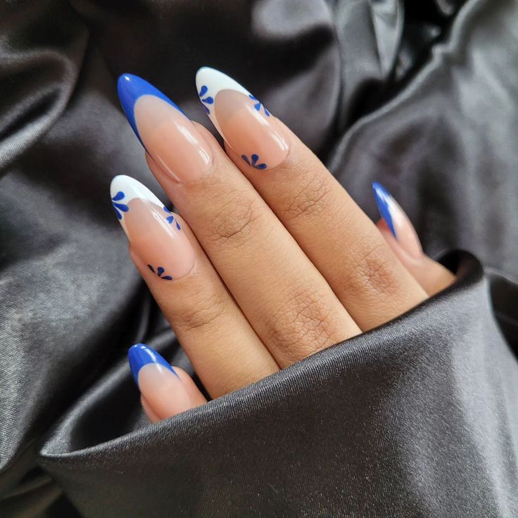 Elegant Stiletto Nail Design with Glossy Blue Tips and Floral Patterns.