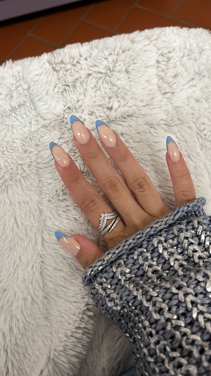 Chic Almond-Shaped Nails with Subtle Nude Base and Delicate Blue Tips for Modern Sophistication.