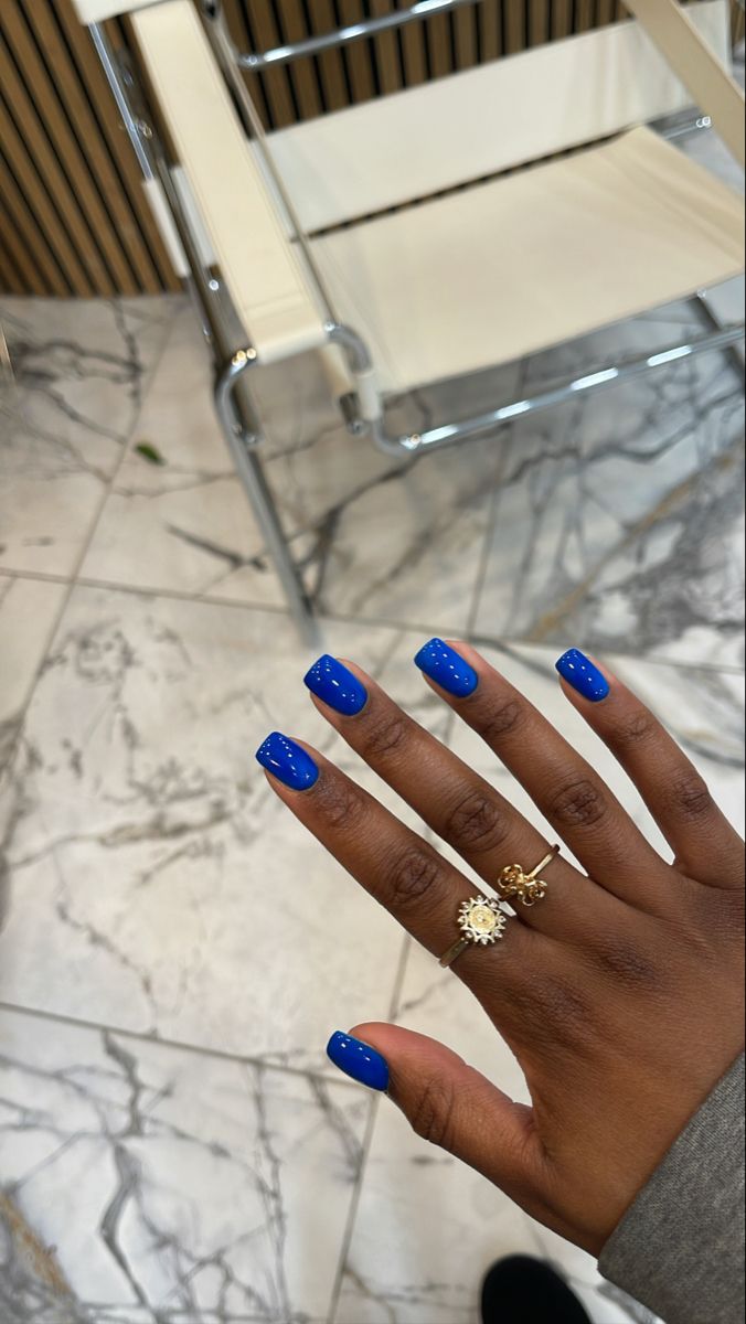 Chic Vibrant Blue Glossy Manicure Enhanced by Stylish Rings.