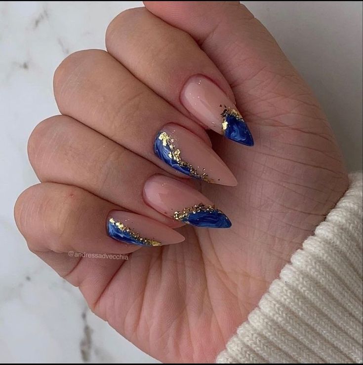 Elegant Almond-Shaped Nails with Gradient Nude and Blue Polish, Enhanced by Luxurious Gold Accents.