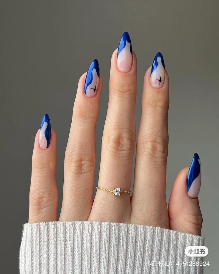 Sophisticated Blue and Nude Almond Nail Design with Flowing Patterns and Gold Accent.