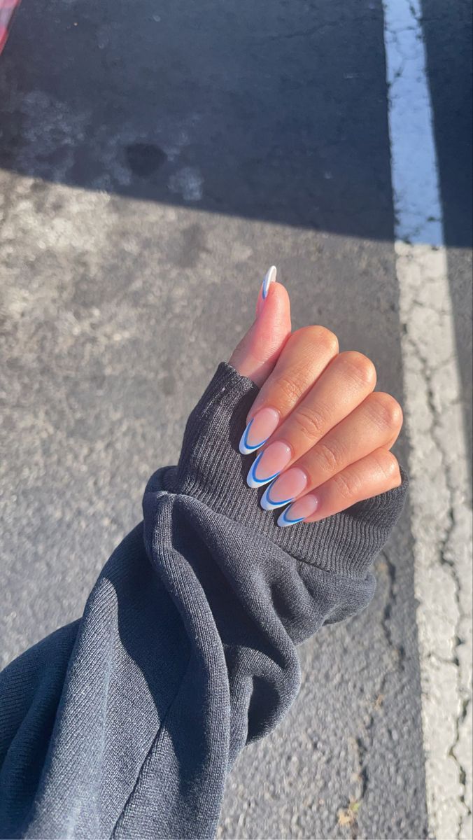 Chic Almond-Shaped Nail Design with Soft Nude Base and Elegant White-Blue Outline.