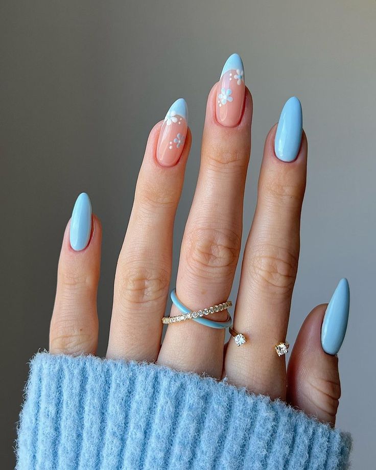 Elegant Almond-Shaped Nail Design in Soft Blue and Pastel Pink with Floral Art and Minimalist Rings.