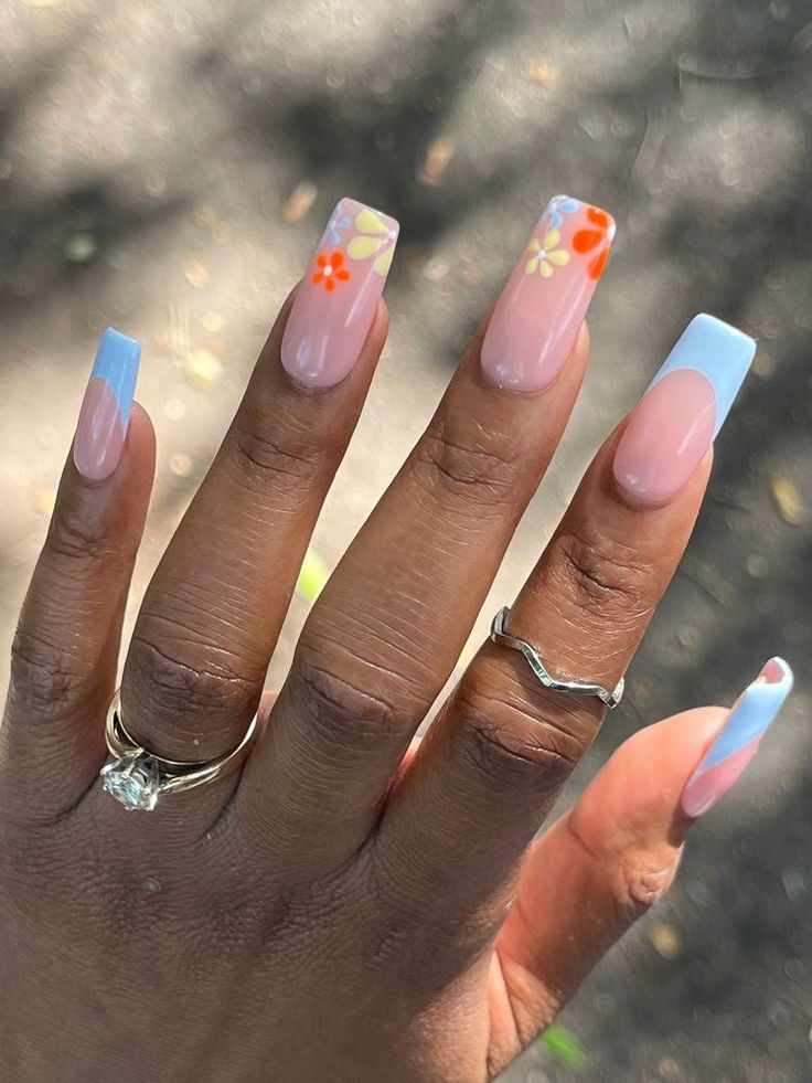 Whimsical Pastel Floral Nail Design with Nude Base and Playful Blue Tips.