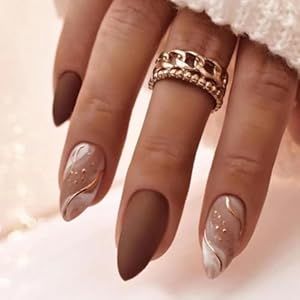 Chic Nail Design: Matte Brown and Glossy Nude with Swirled White Accents and Stylish Rings