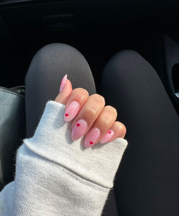 Charming Delicate Pink Nail Design with Heart Accents for a Playful Aesthetic.