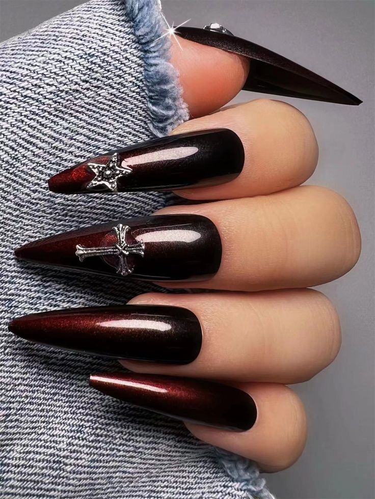 Gothic Stiletto Nail Design: Deep Burgundy and Black with Shimmering Silver Accents.