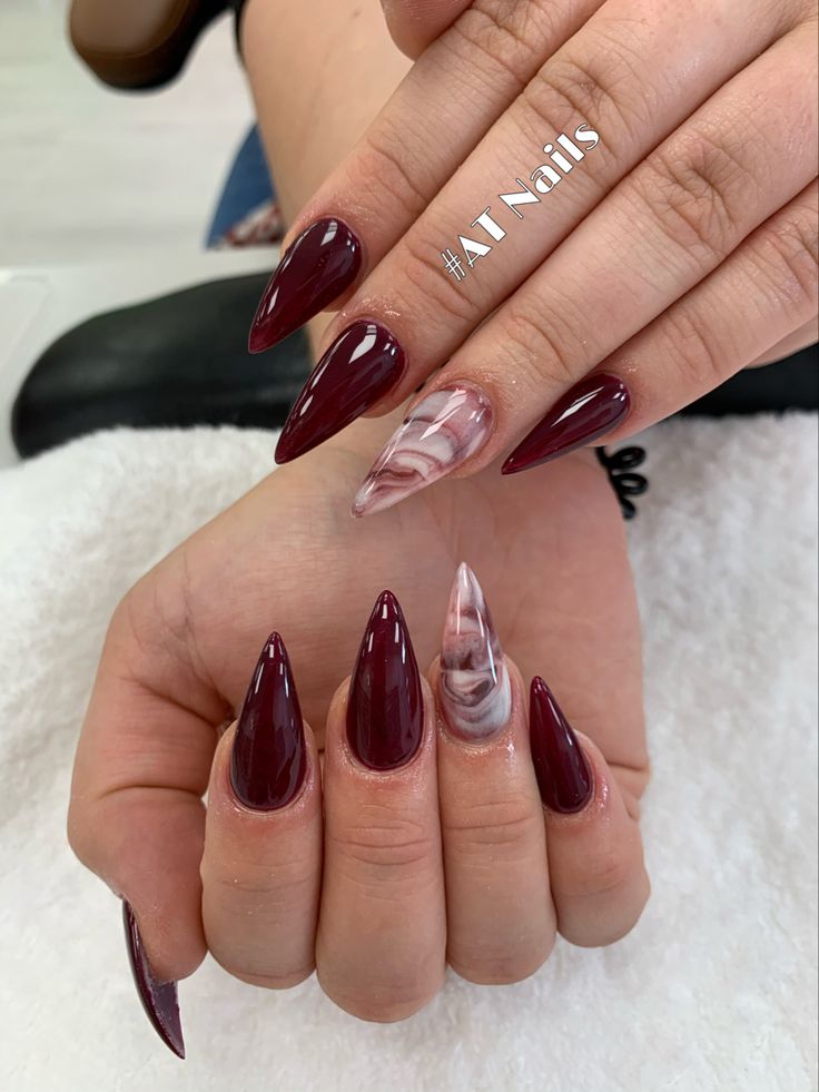 Elegant Almond-Shaped Nails with Deep Burgundy and Marbled Accent Design.